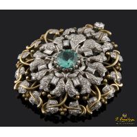 Broche realizado en oro amarillo y oro blanco. Presenta una esmeralda natural colombiana, diamantes y brillante.