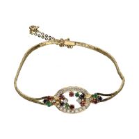 Pulsera en oro amarillo con esmeraldas, rubíes, zafiros y brillantes.