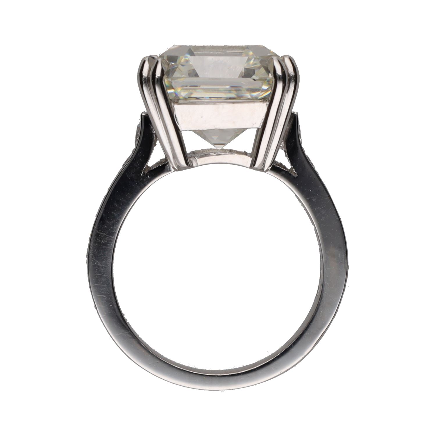 Sortija en platino con diamantes talla esmeralda central y brillantes.