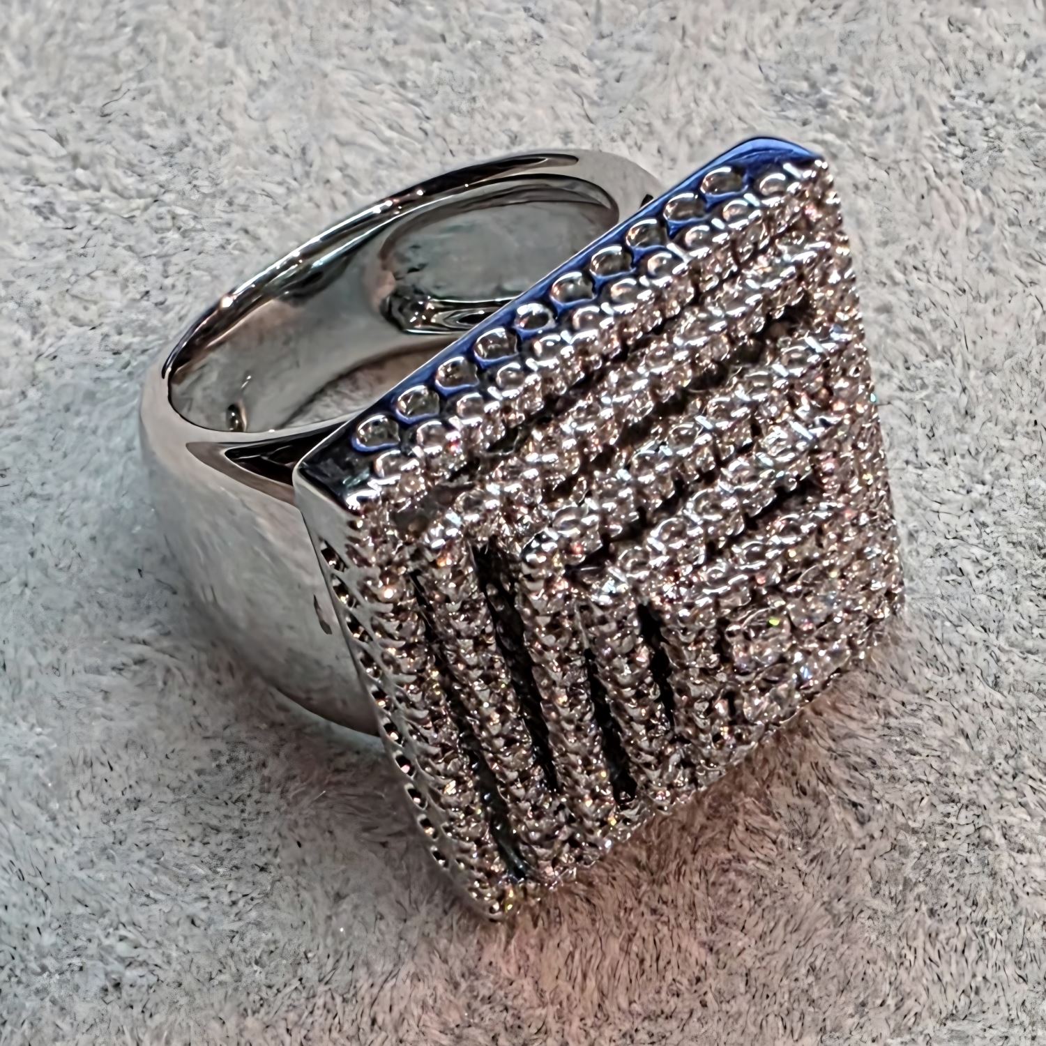 Sortija ancha con forma de pirámide en oro blanco con brillantes. Talla 14.