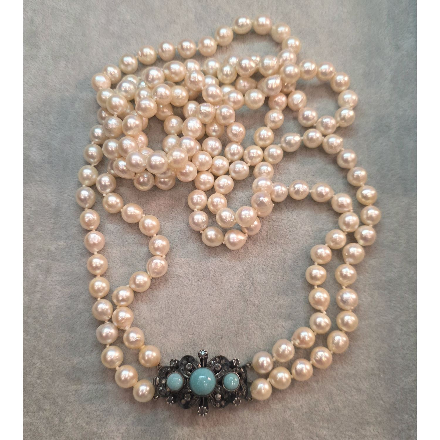 Collar de perlas con cierre en plata con turquesas y diamantes.